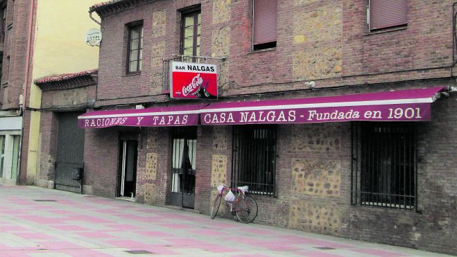 Situado, se decía entonces, en los arrabales de la ciudad (foto superior)se mantiene en el mismo lugar pero ya integrado en la ciudad. También mantiene la esencia de lo que fue desde el principio, una casa de comida tradicional. Debe su nombre a otra ‘tradición’ muy leonesa, la de los apodos, y su primer dueño (Felipe Vega) era conocido por ‘Nalguinas’ (después se quedó en Nalgas)por su físico endeble, de baja estatura, frente a la «rotundidad y exhuberancia de su mujer, Librada Dorado», dice Roberto Cubillo en su libro ‘Aquella hostelería de León’ 