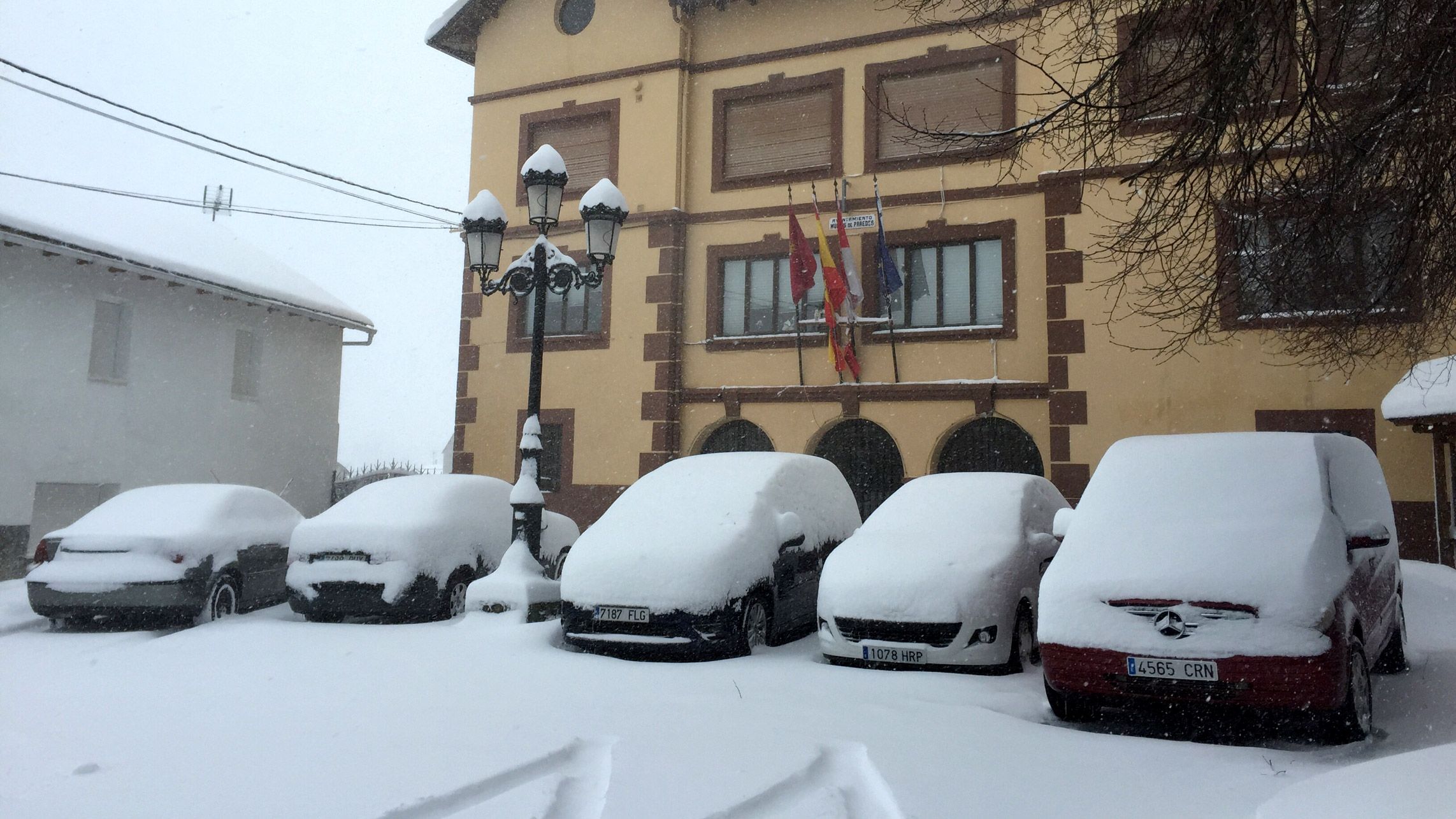 Coches cubiertos por la nieve en Murias de Paredes. | CARMEN MALLO