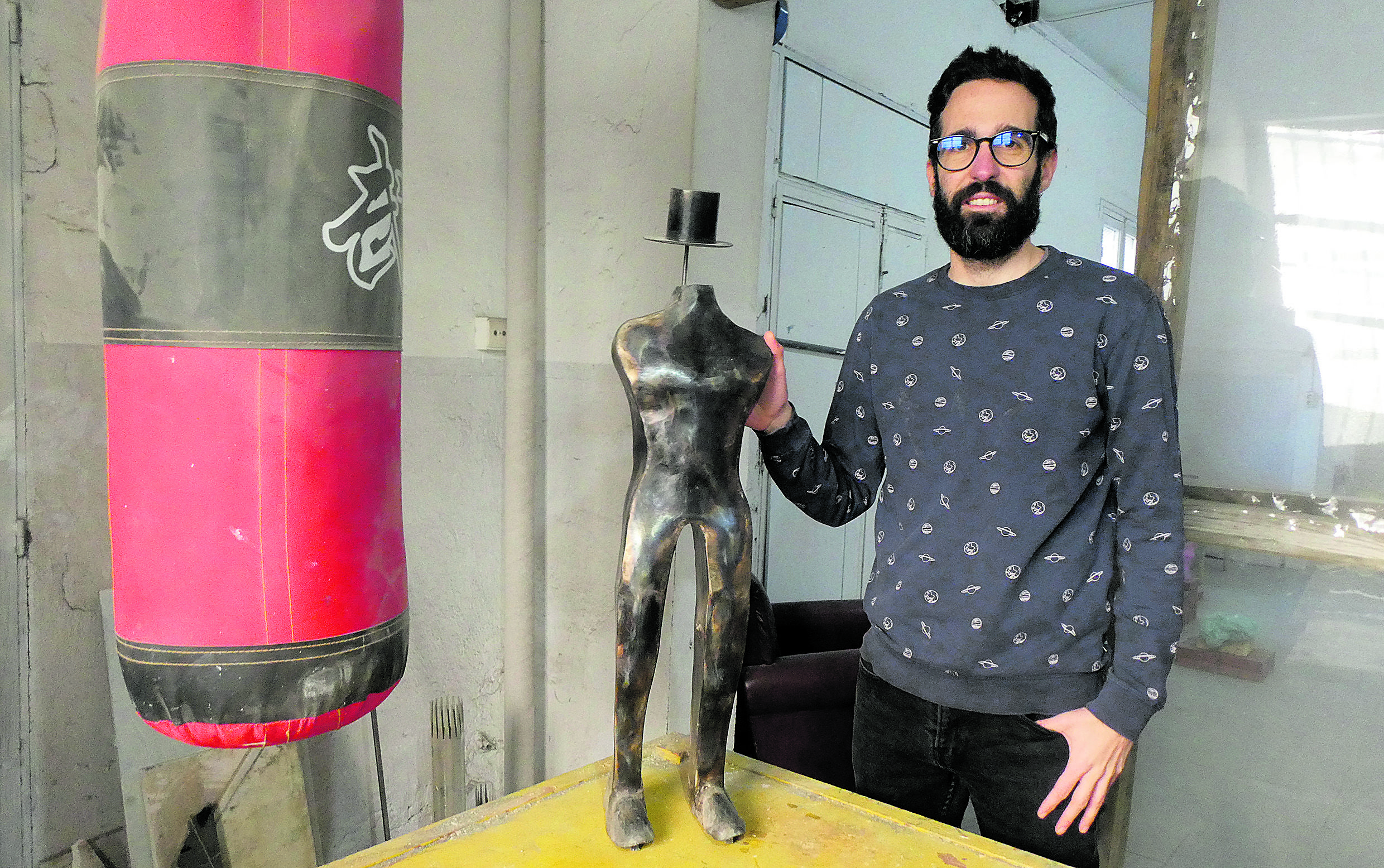 Al lado de un saco de boxeo, Efraim se presenta con una de sus piezas artísticas. | GREGORIO FERNÁNDEZ CASTAÑÓN