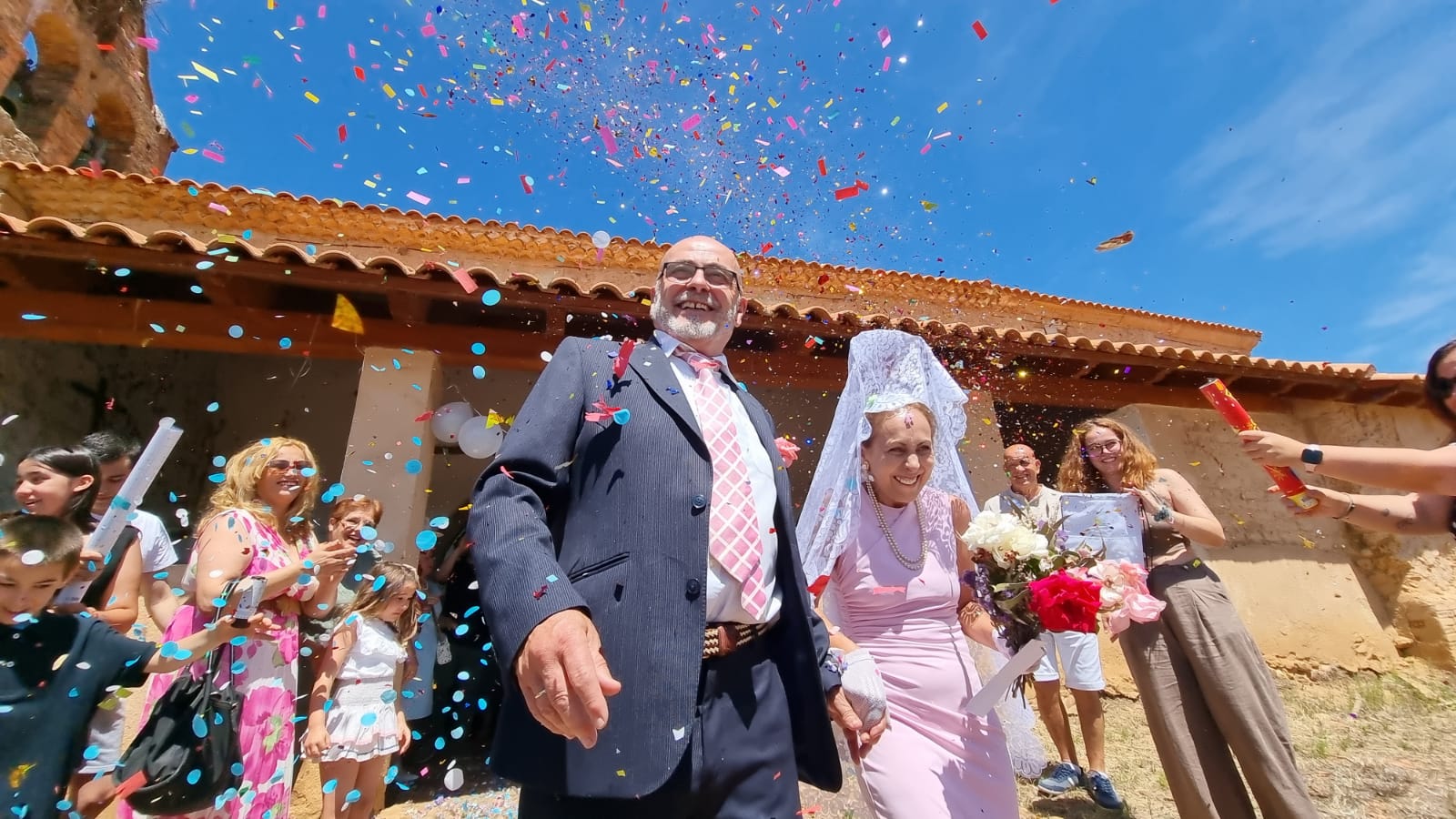 Saturio y María, los recién casados, en su salida de la iglesia, acompañados por algunos de sus invitados. | ANDRÉS GUTIÉRREZ CADENAS