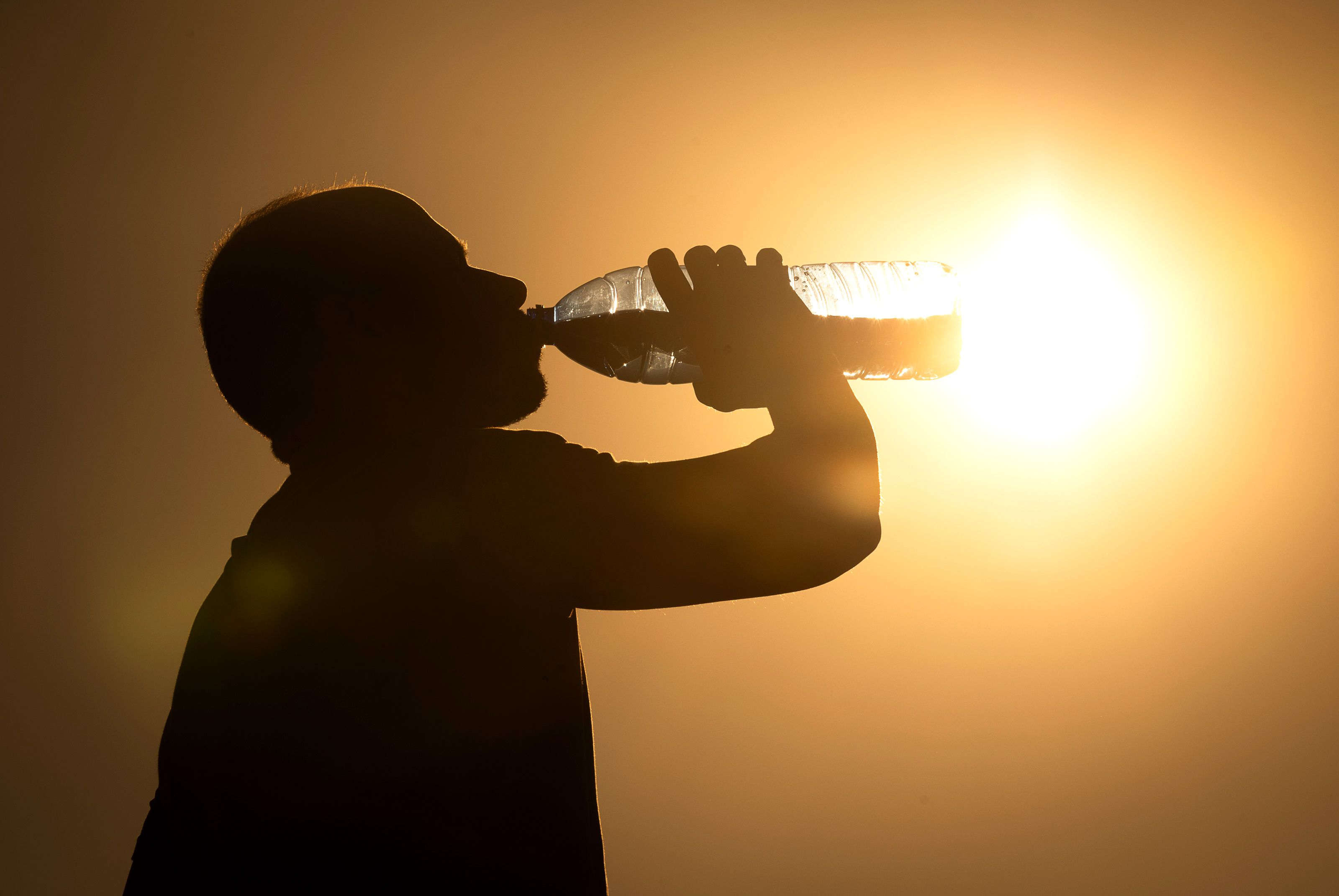  Un hombre bebe agua bajo un sol que ha aumentado las temperaturas en la comunidad. | ICAL