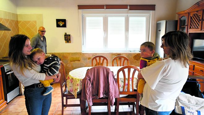 Victorino y Óscar, de 16 y 6 meses, en brazos de su madre Judith y su abuela María Dolores, bajo la atenta mirada del abuelo Óscar, en Azadón. | SAÚL ARÉN