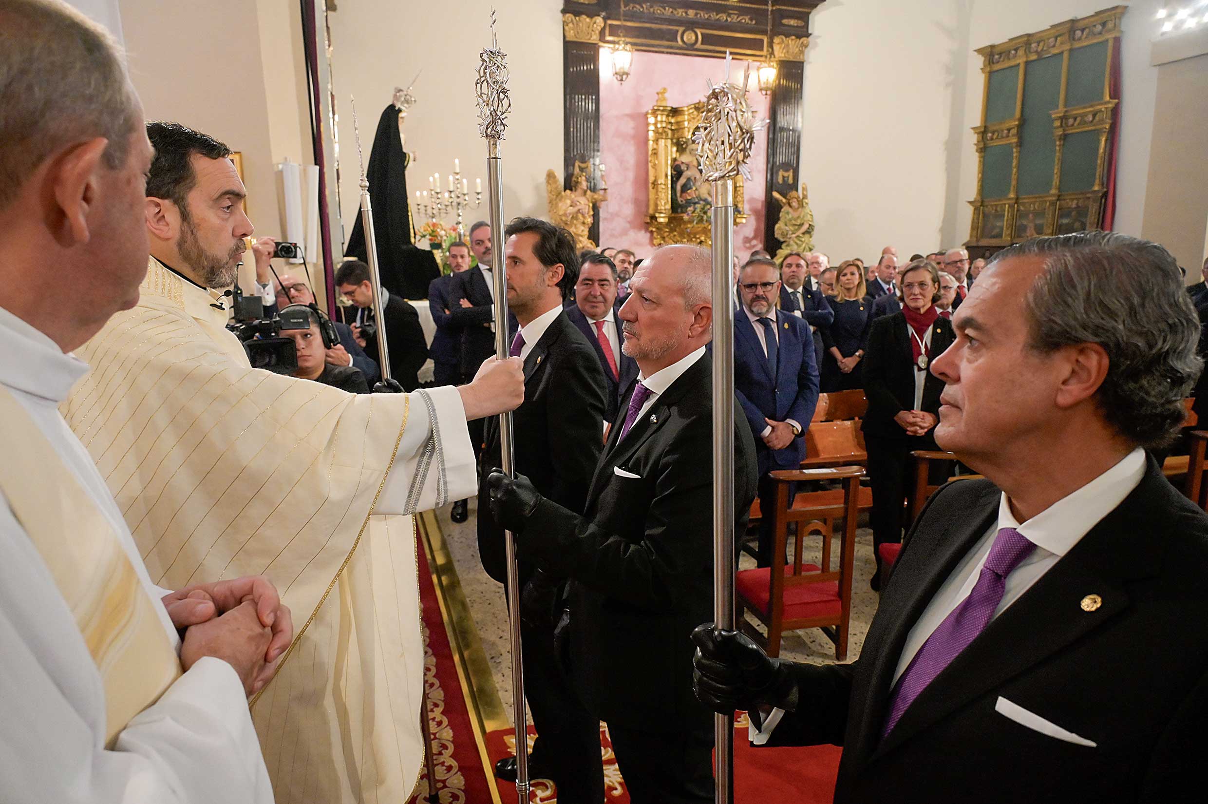 El párroco, Manuel Flaker, hace oficial el cambio de varas entre Sergio González y Nacho Tejera, en la capilla de Santa Nonia. | MAURICIO PEÑA