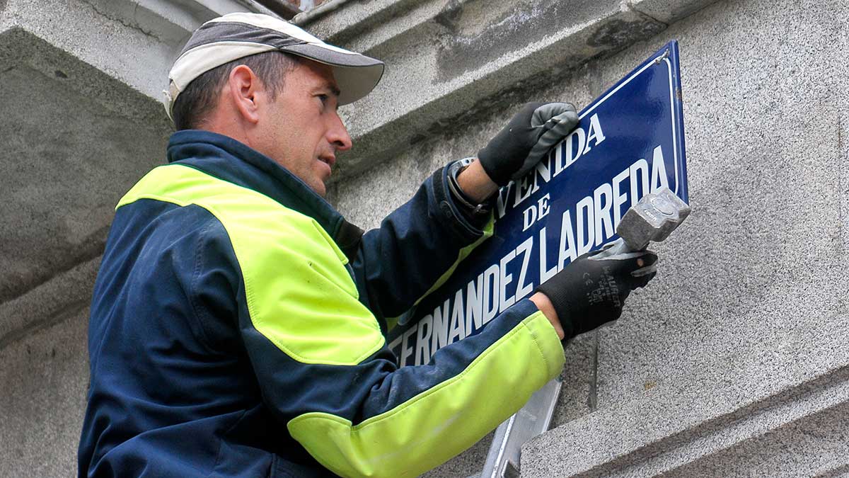 Un operario sustituye la placa de la calle en Segovia. | ICAL