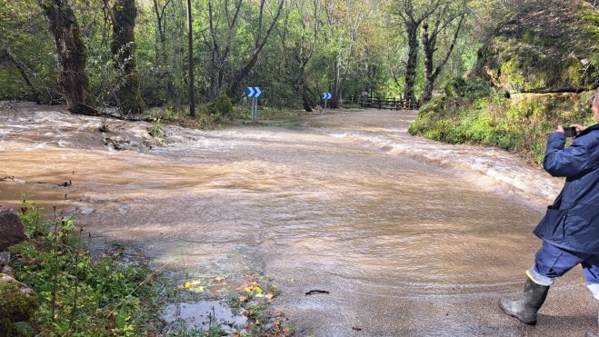 La carretera de acceso al pueblo, cortada por la riada.