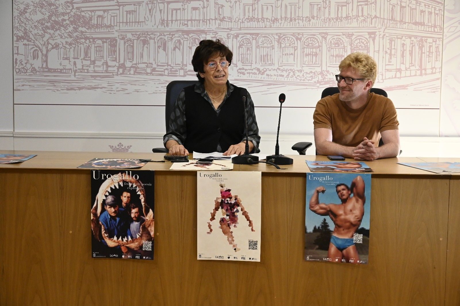 Elena Aguado y Manuel Alonso en la presentación del Festival Urogallo 2024 con los carteles de Eduardo Fandiño a la vista. | SAÚL ARÉN