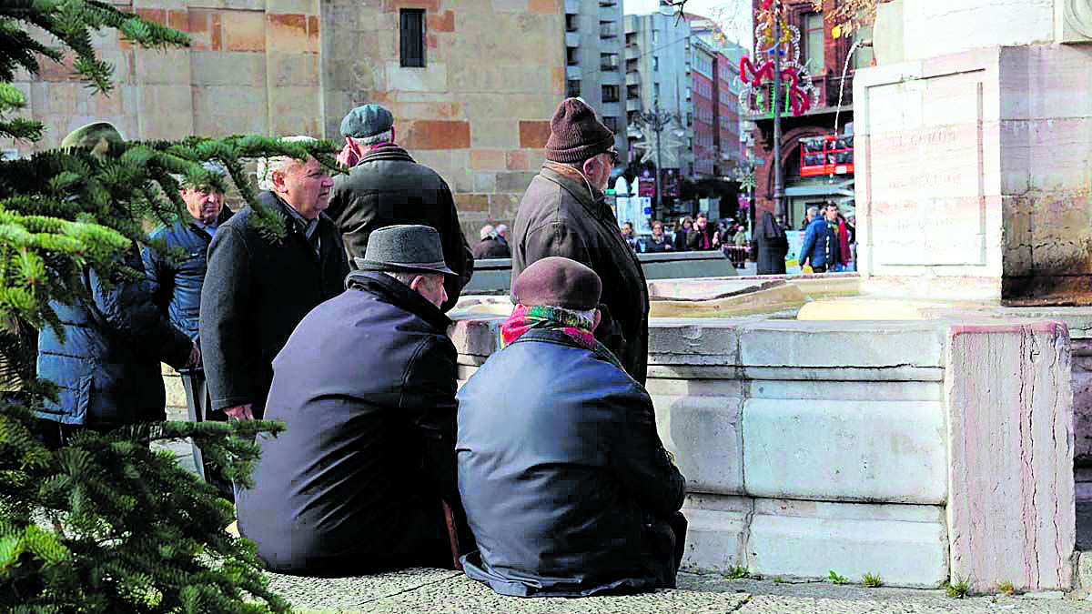 Varios jubilados leoneses charlan junto a la fuente de San Marcelo en una imagen de archivo. | CÉSAR