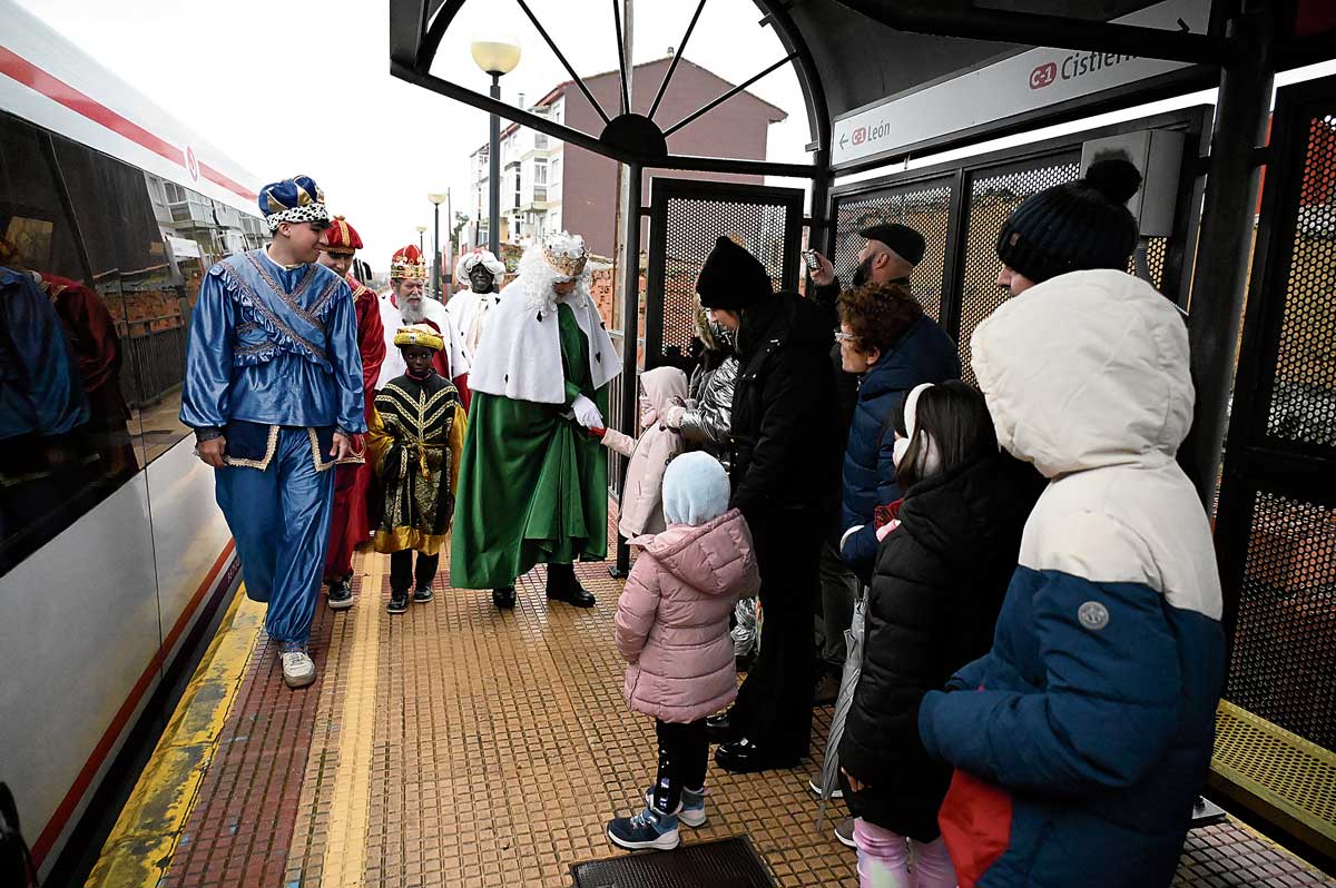 Melchor, acompañado por el resto de la comitiva real, saluda a uno de los niños que se acercaron a recibirles en el apeadero de La Raya. | SAÚL ARÉN