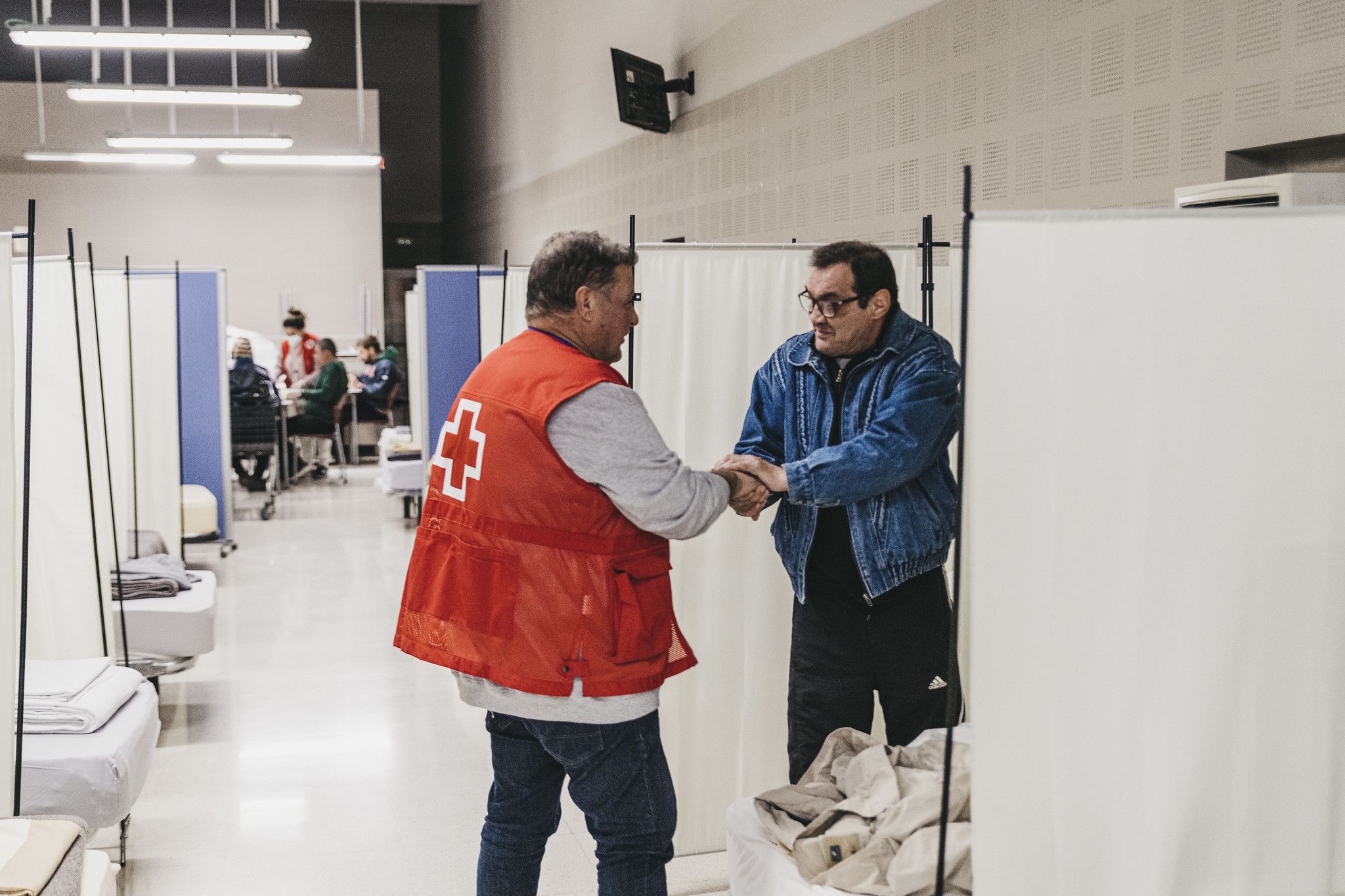 Un voluntario atiende a una persona en el Centro de Emergencias Sociales de Valencia. | CRUZ ROJA