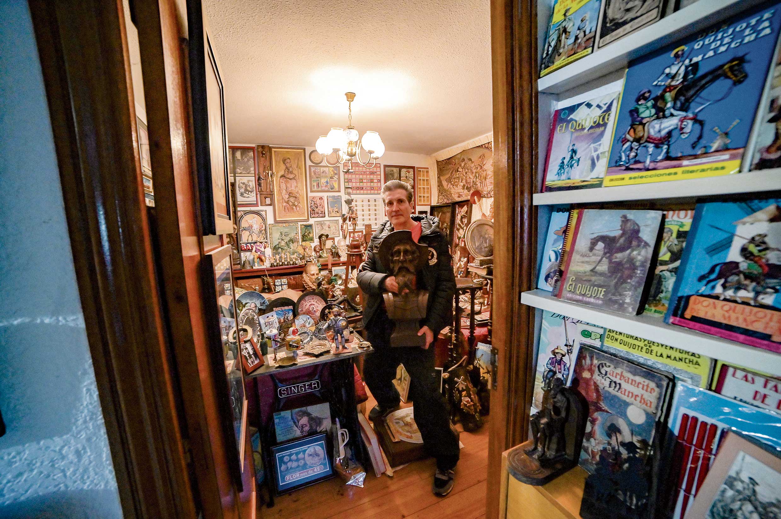 Fernando Bandera con un busto de Don Quijote en una habitación en la que se acumulan cientos de piezas del ‘Ingenioso’. | MAURICIO PEÑA