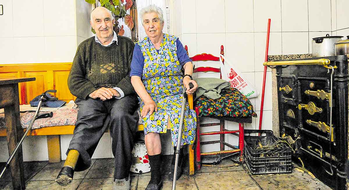 Carpo y su hermana Carmina en el escaño de la cocina y al calor de la ‘económica’ que tantos platos cocinó durante muchos años en Tolibia. MAURICIO PEÑA