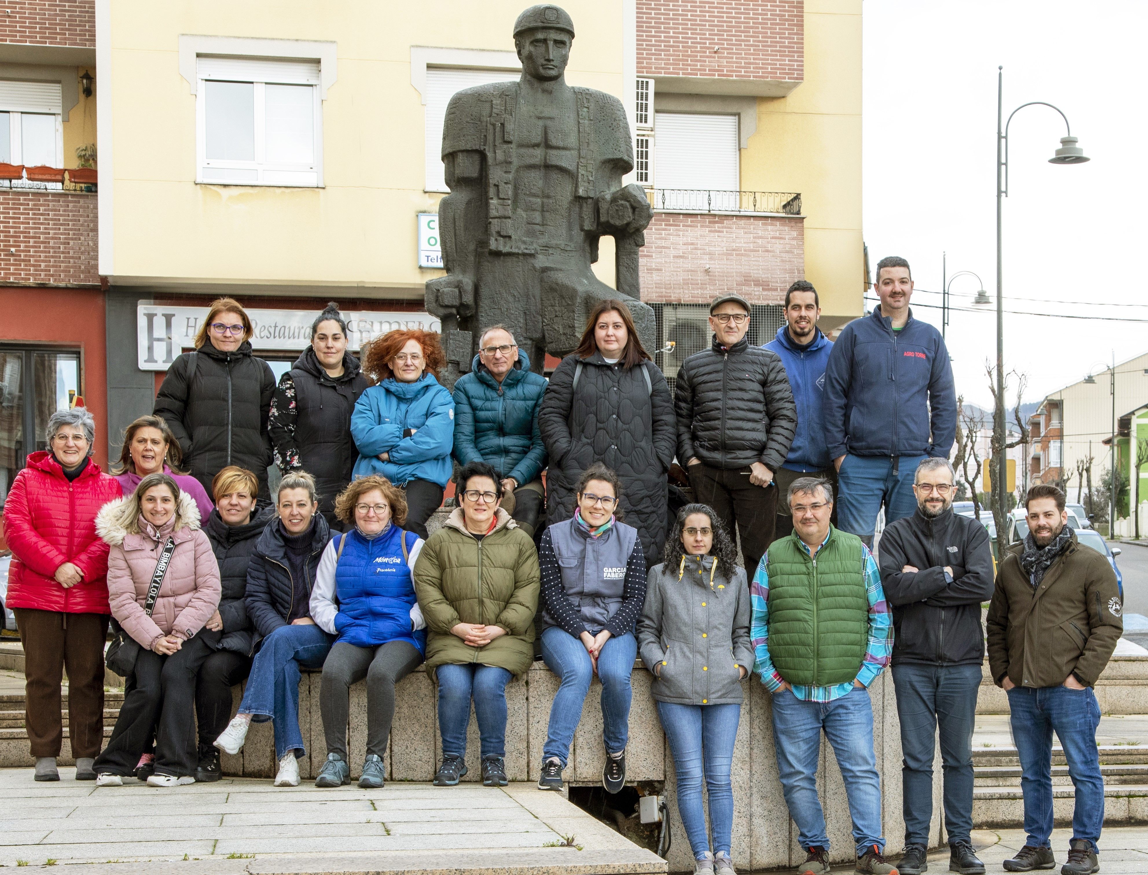 Integrantes de la Asociación de comerciantes de Fabero, al lado de la estatua al minero. 