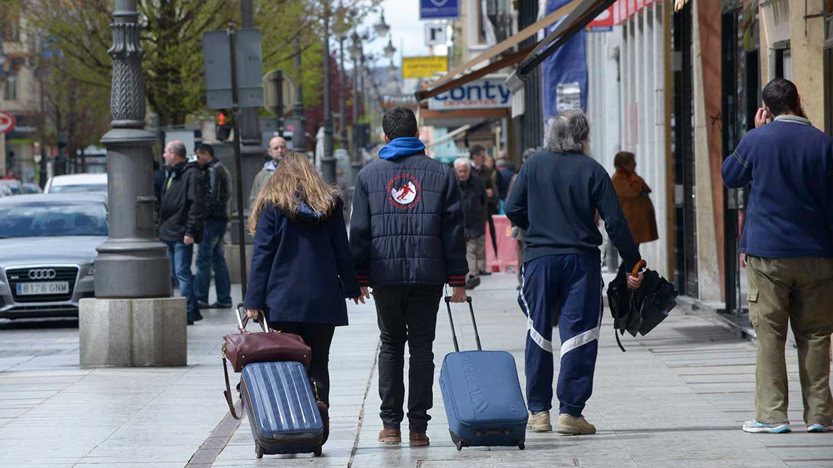 Dos leoneses paseando con su maletas en dirección a la estación de trenes. | MAURICIO PEÑA