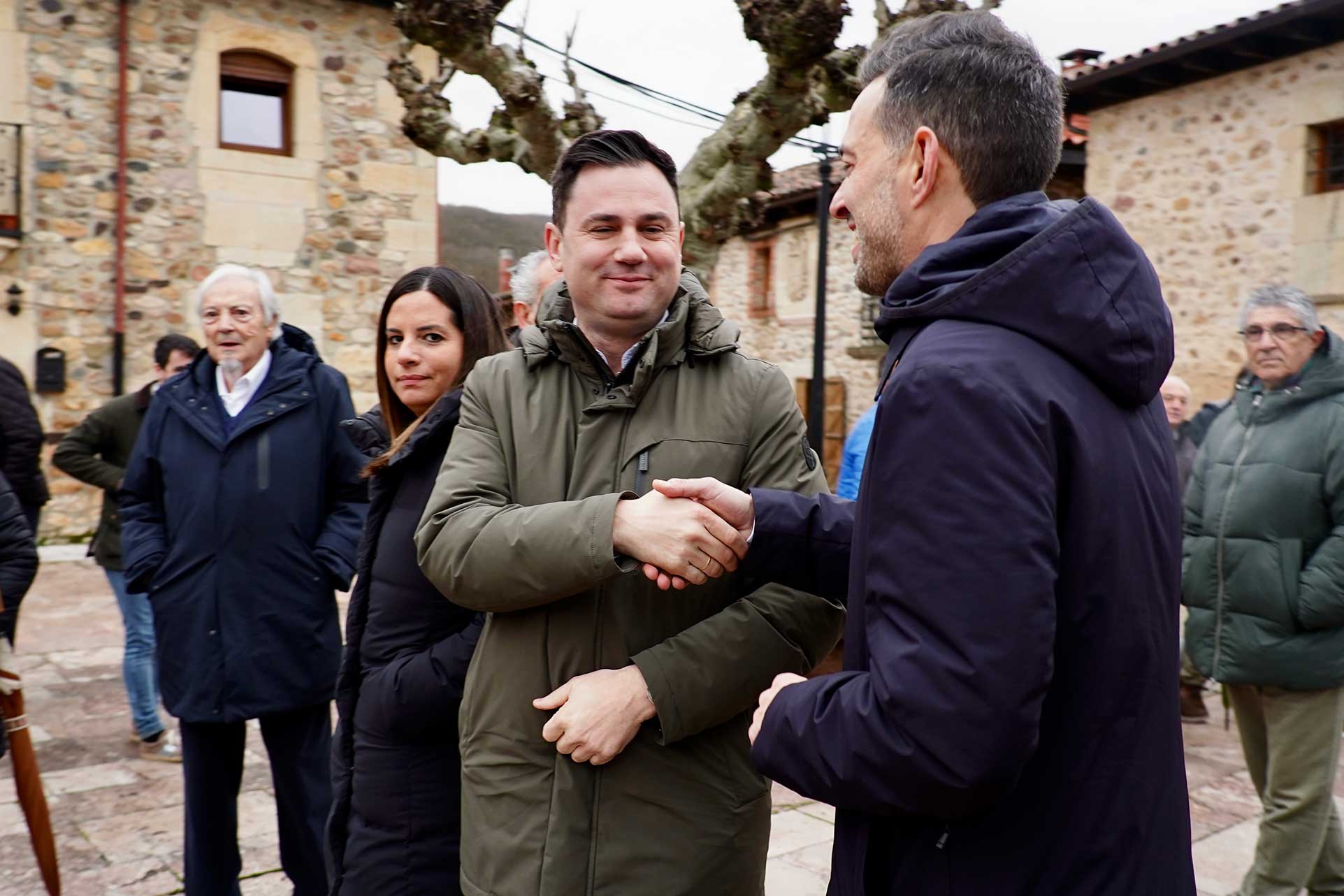 Nuria Rubio detrás de Javier Alfonso Cendón y Diego Moreno saludándose este sábado en La Vecilla. | CAMPILLO (ICAL)