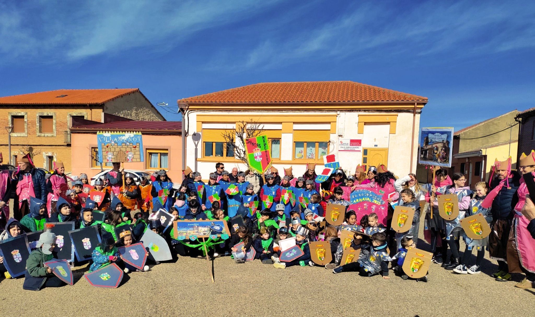 Comunidad educativa del CRA El Burgo Ranero delante de la escuela rural de Santas Martas