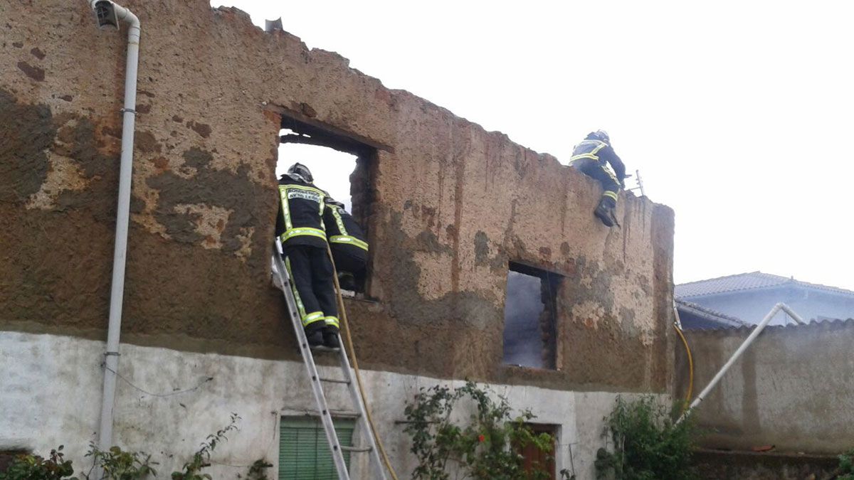 Los Bomberos de León sofocando las llamas del incendio en Lugán.